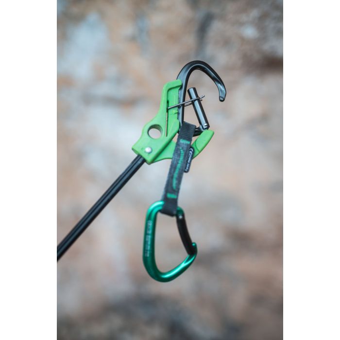 Green carabiner with a black rope against a blurred natural background